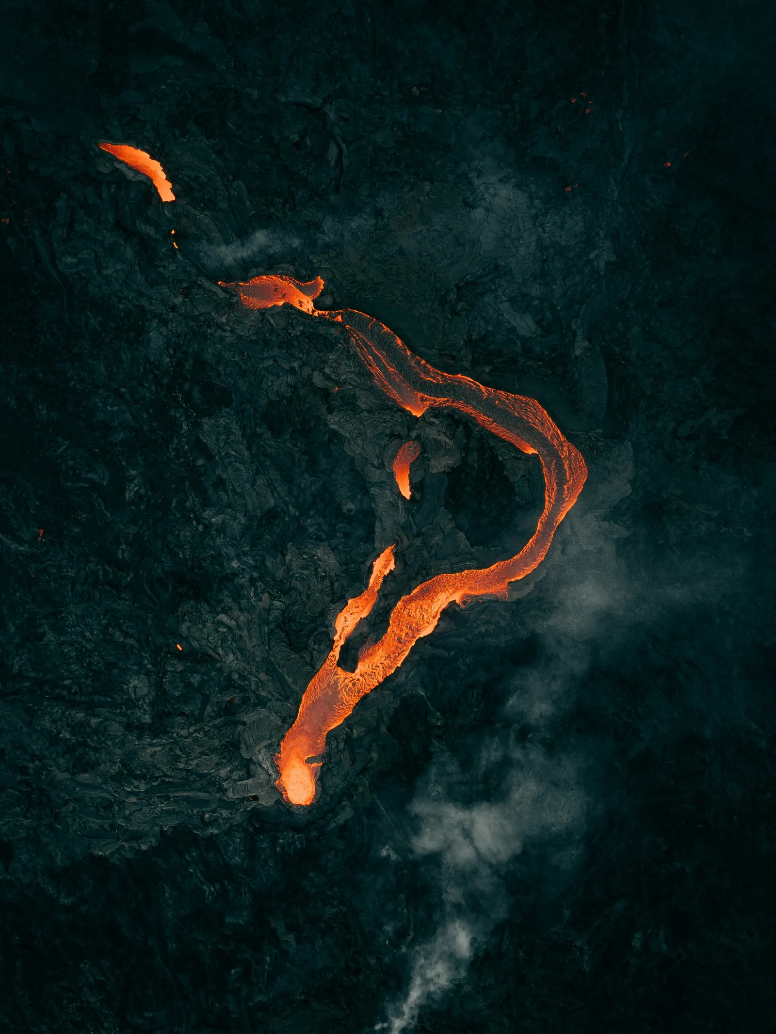 Vena de lava serpenteante sobre roca negra